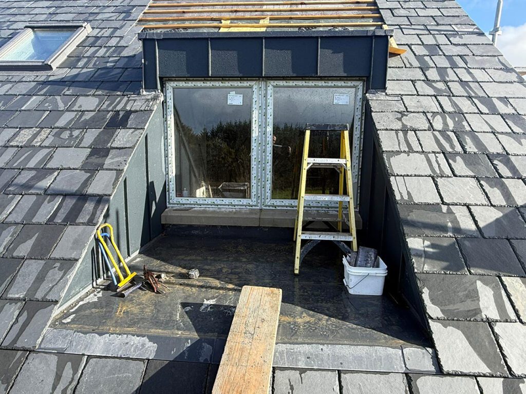 House in Bushmills - 2 PVC flat roofs, 4 dormers done with Strata waterproofing PVC single ply details and one wrapped in Prefa aluminium anthracite standing seam cladding