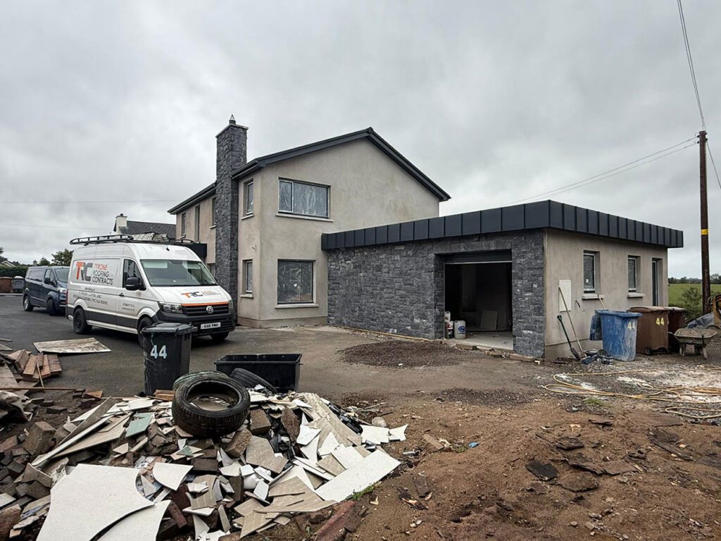 House in Dungannon with 100m2 Strata waterproofing PVC flat roof wrapped with Prefa anthracite aluminium standing seam panels