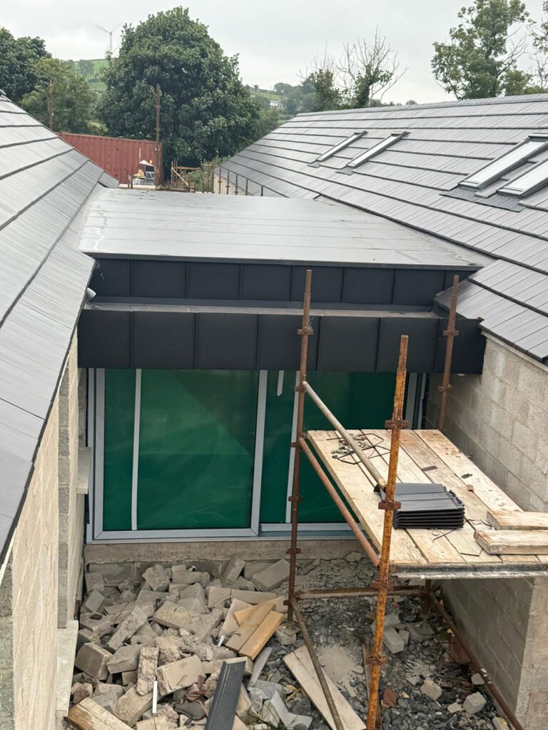 Job in Ballynahinch with Strata waterproofing PVC single ply roof then wrapped with black elzinc aluminium standing seam panels